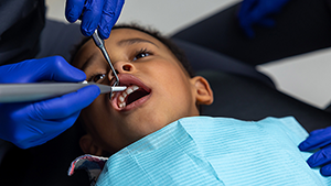 Examen dentaire réalisé sur un enfant par un dentiste