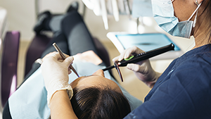 Dentiste réalisant un soin dentaire avec des loupes de précision en cabinet
